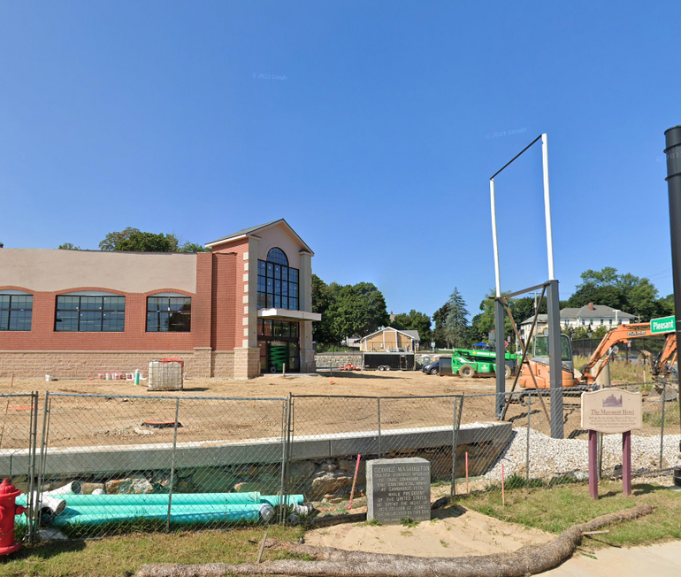 A building under construction behind two historical markers