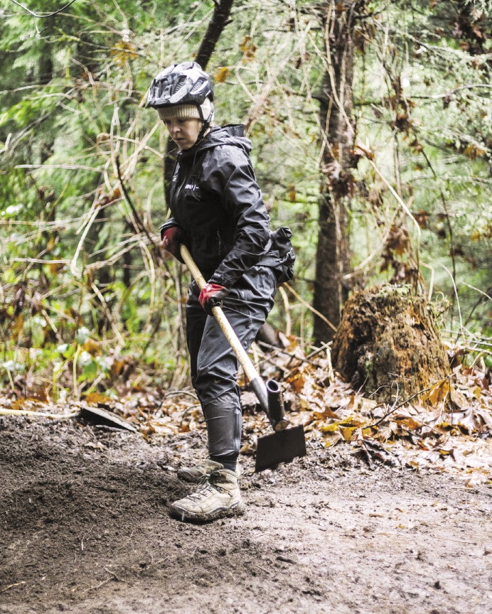 A woman uses a trail digging tool