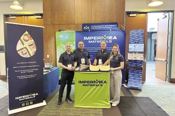 Four people stand at marketing booth