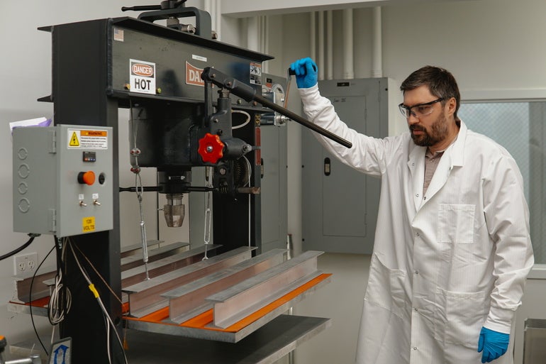 A lab worker uses machinery