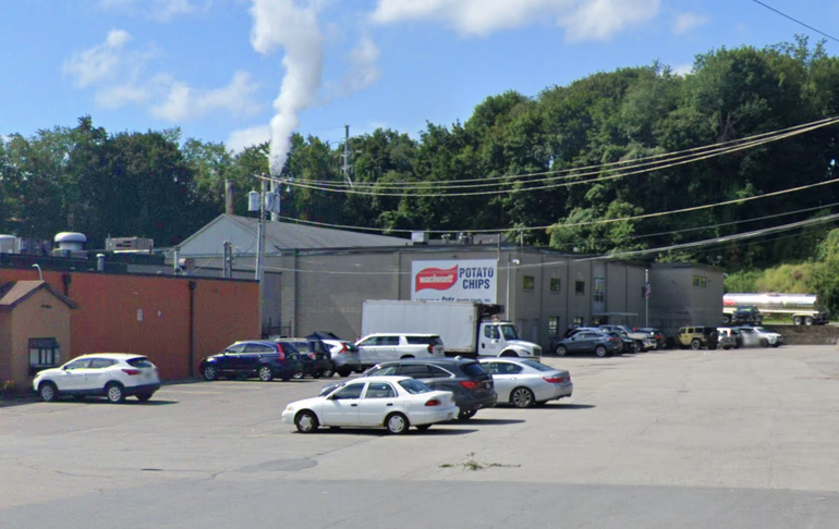 A factory sits behind a parking lot