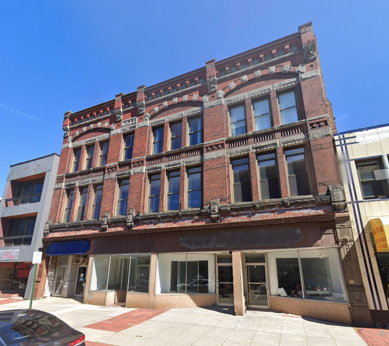 A three-story brick building in an urban area