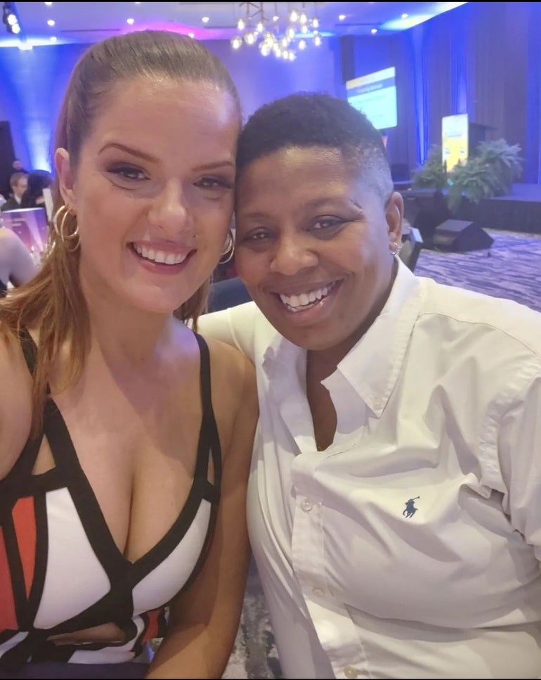 Two women smile at the camera at an awards event.