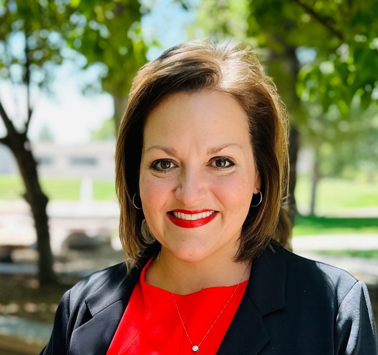 A woman in a suit jacket and red dress or blouse