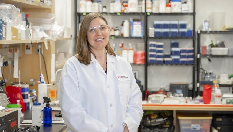 A woman in a lab coat standing in a lab