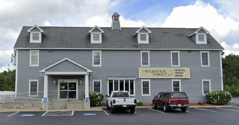 A building with blueish grey siding and a steeple on top
