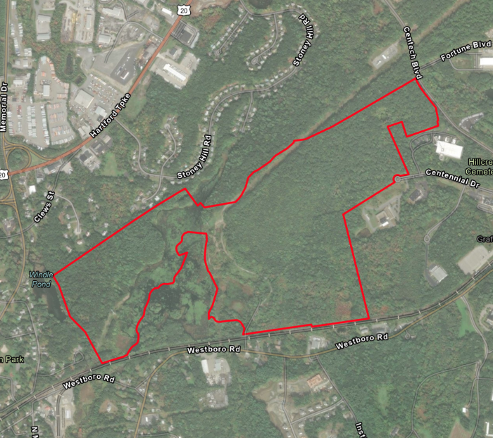A satellite image of a wooded area, outlined in red