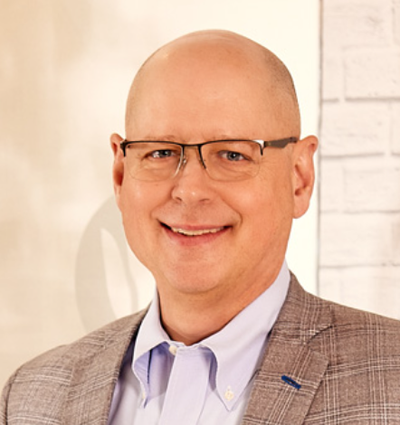 A man in a suit jacket with glasses