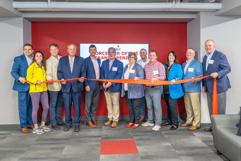 A group of people cutting a ribbon