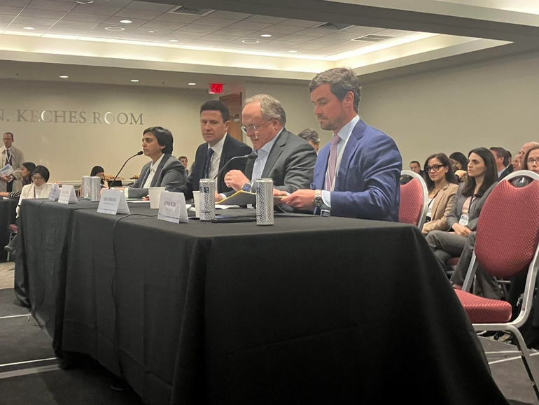 Four people sit at a table during a hearing