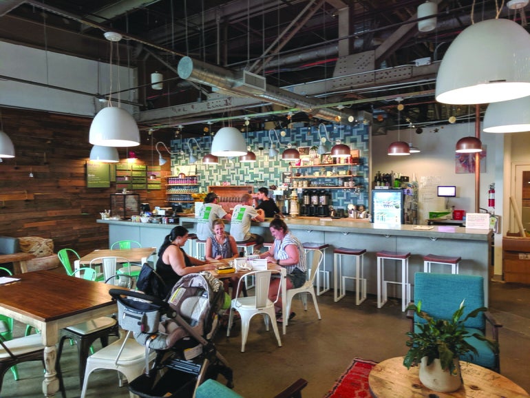 Five people sit in a brewery tap room with a server behind the bar