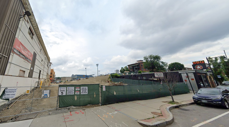 An empty construction lot behind a fence
