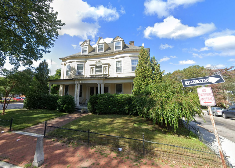 A three-story white Victorian house
