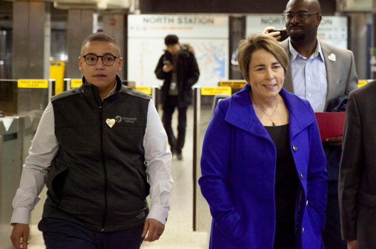 Two people walking towards the camera in a subway station
