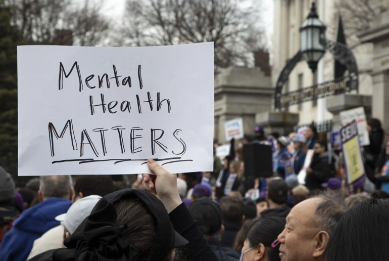 A protest sign behind held up at a rally