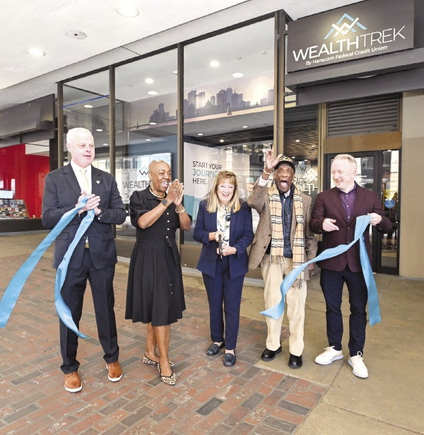 Group of five people clap after cutting a ribbon