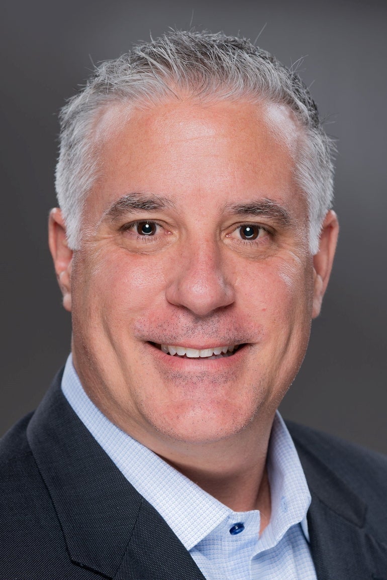 Headshot of a man in a suit jacket and dress shirt