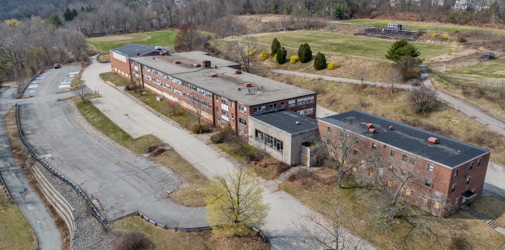 An aerial view of an abandoned high school and athletic fields