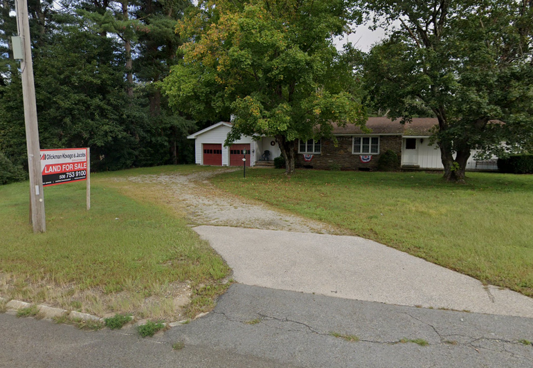 Single family house with land for sale sign in front 