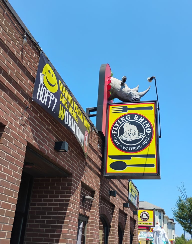 The sign for a restaurant hanging above the entrance to a brick building