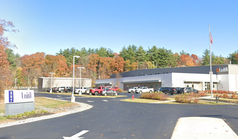 A industrial building with parking lot in front