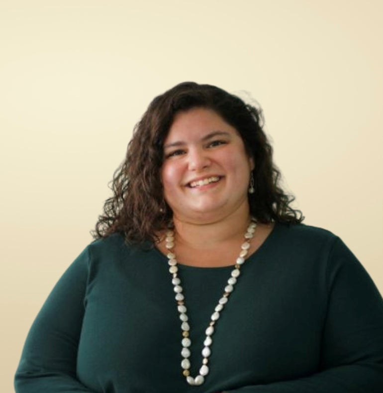 A woman in green shirt with a necklace