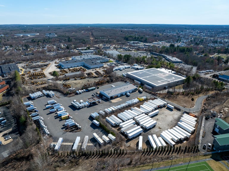 Aerial view of a large industrial site with many truck trailers and a maintenance building 