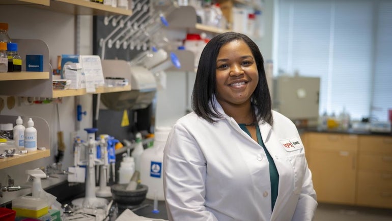 Woman in a lab coat stands in a lab