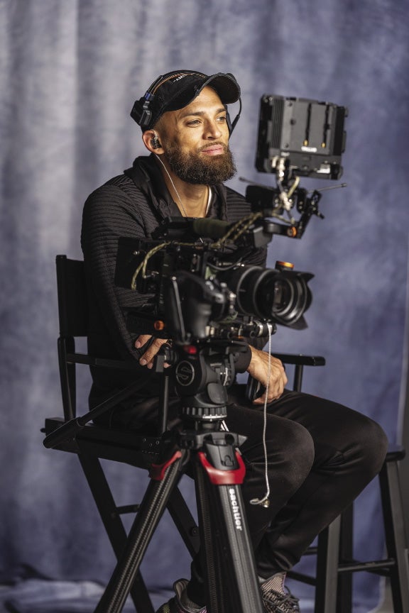 Man in black clothing sits in director's chair