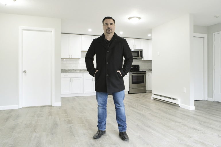 A man stands in an empty apartment