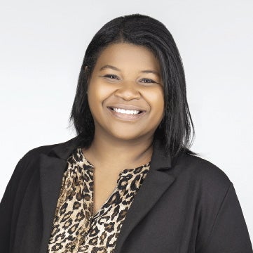 A woman with black hair smiles at the camera.