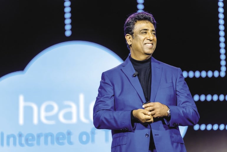 A photo of Girish Navani giving an on-stage presentation