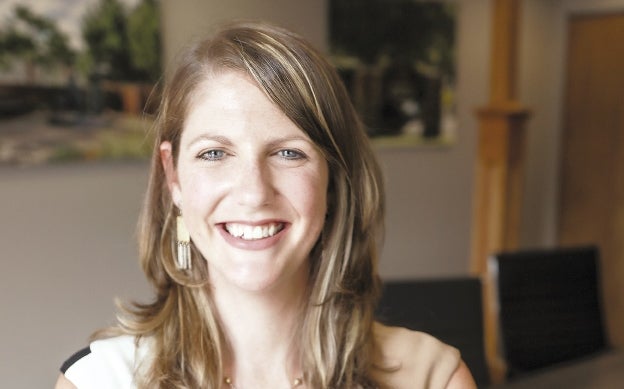 A woman with her arms crossed, smiling