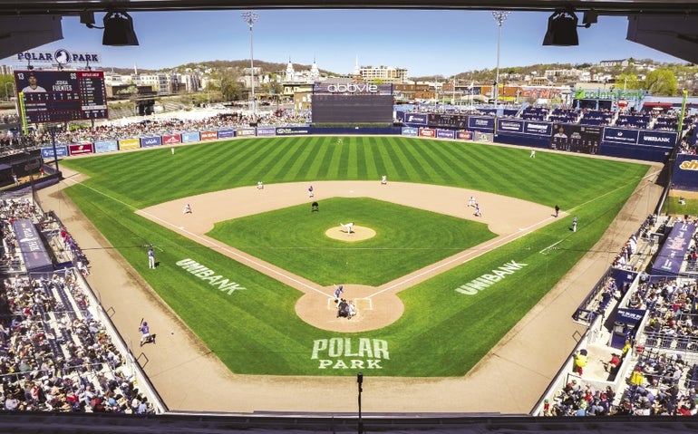 A view of a baseball field from high above home plate with stadiums of stands surrounding it.