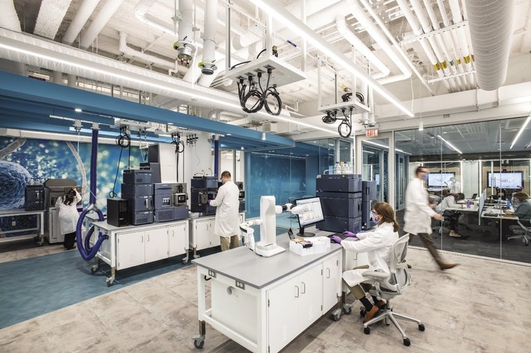Three lab technicians working in a large laboratory space