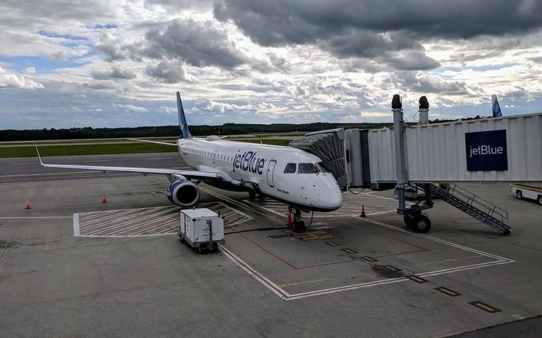 A large white JetBlue plane on a tarmac