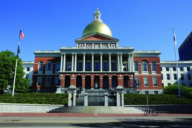 A large brick building with columns in front and a gold dome on top.