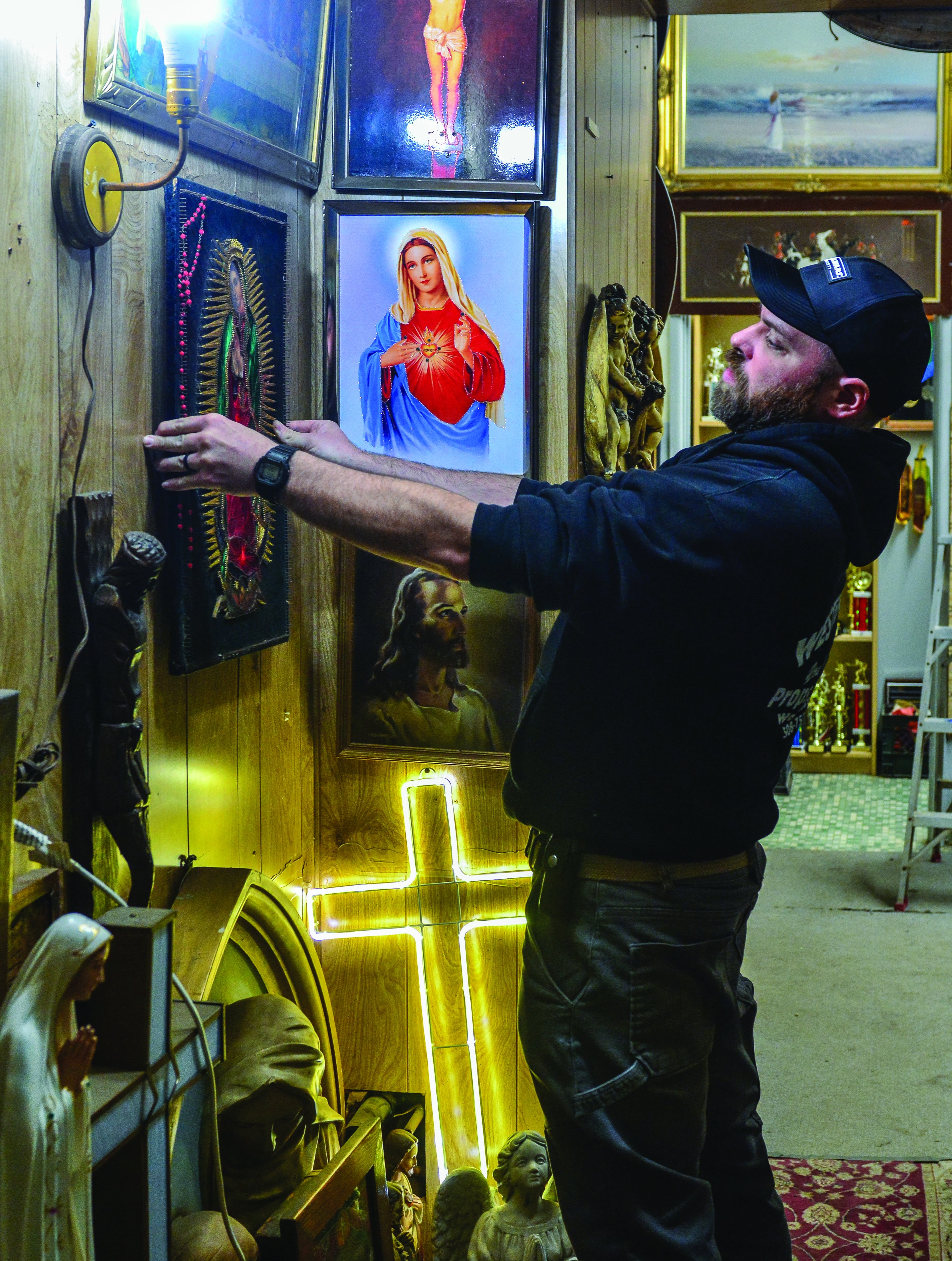 A man straightens a painting