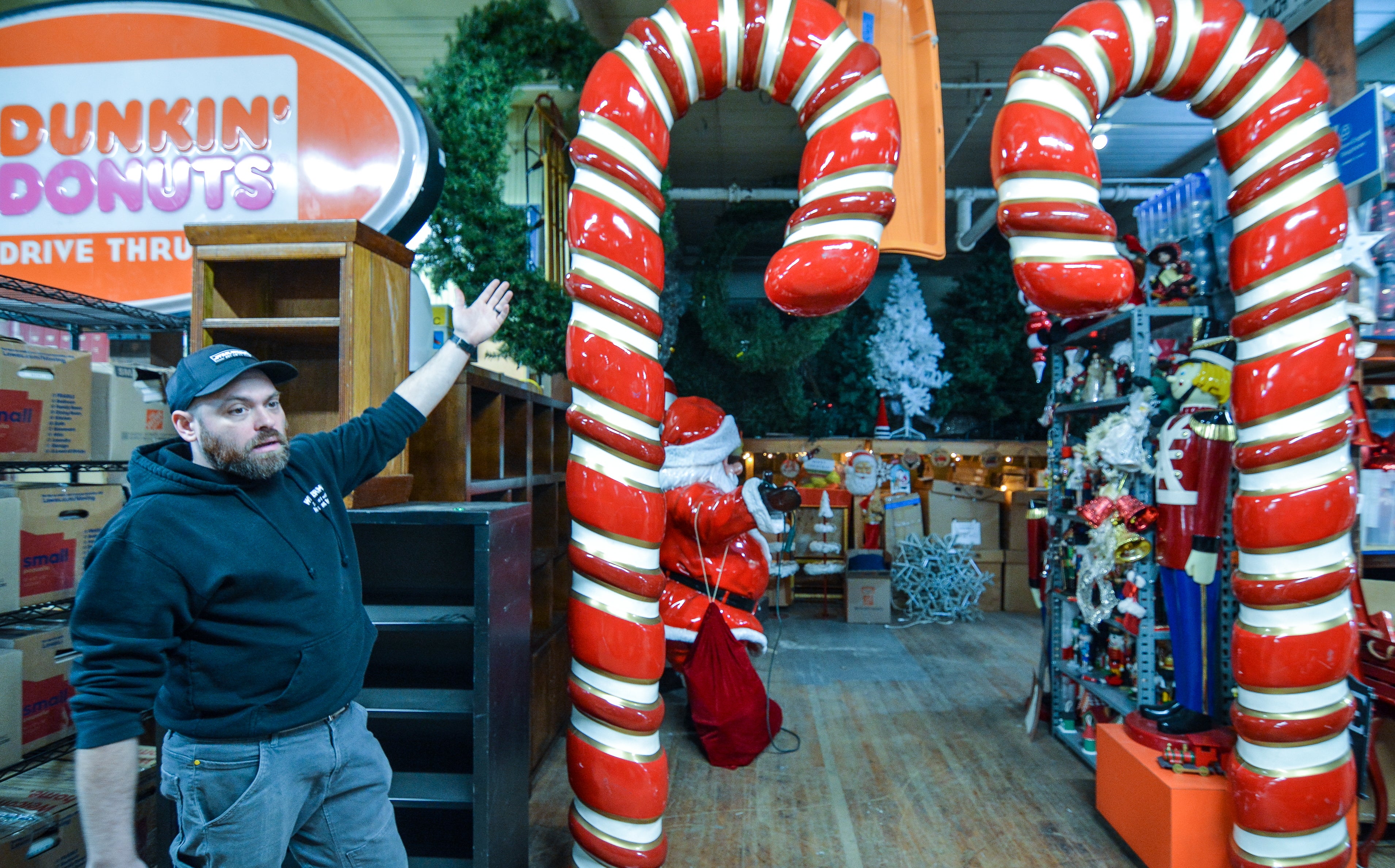 A man points at two very large candy canes