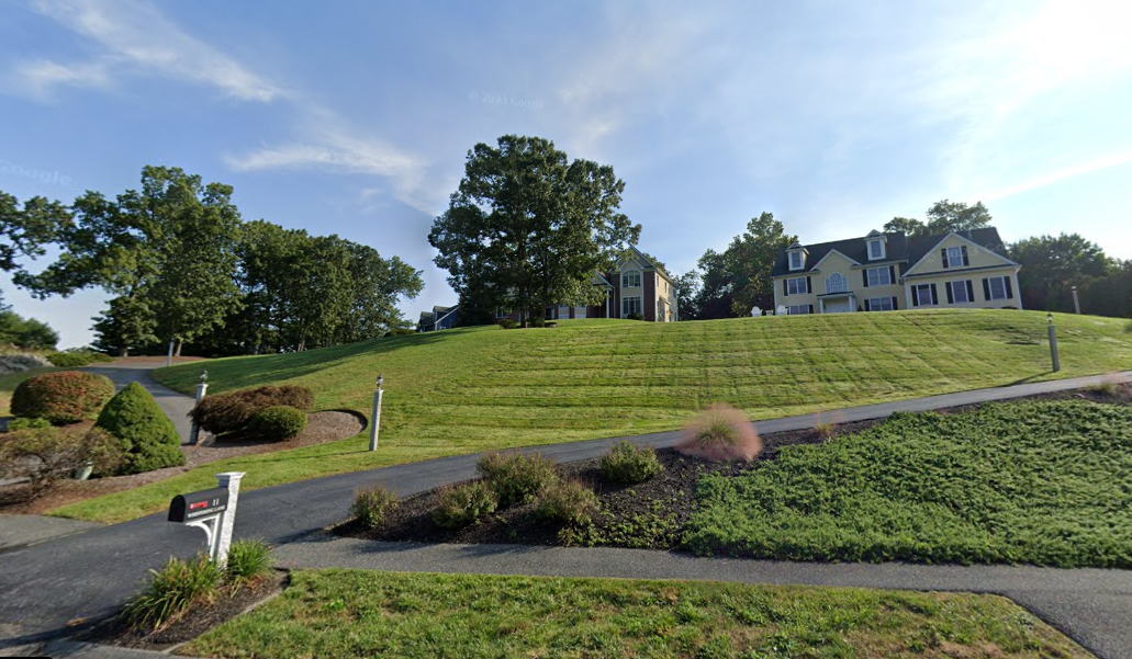 Two large home sit on top of a hill