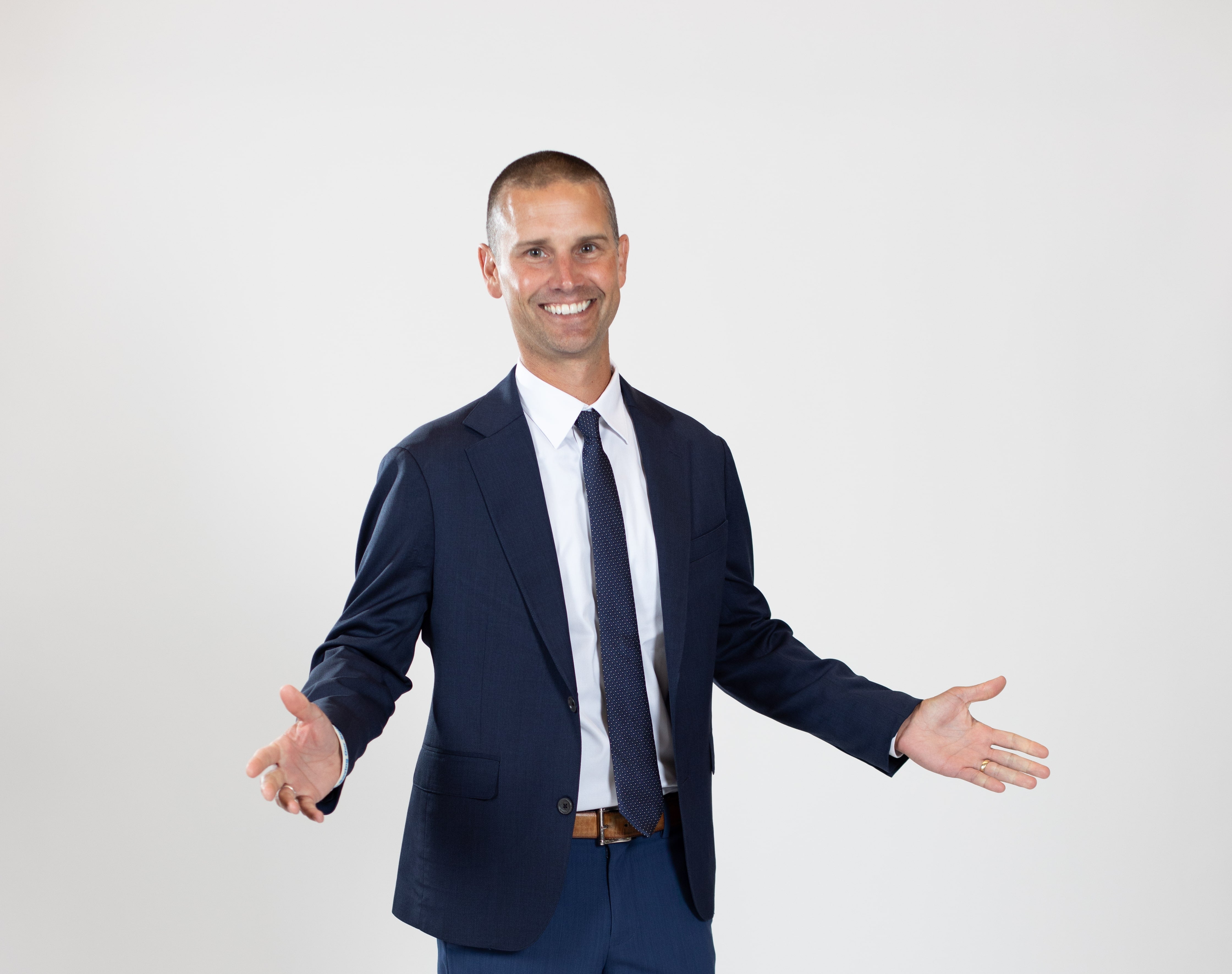 A man wears a blue jacket and blue tie