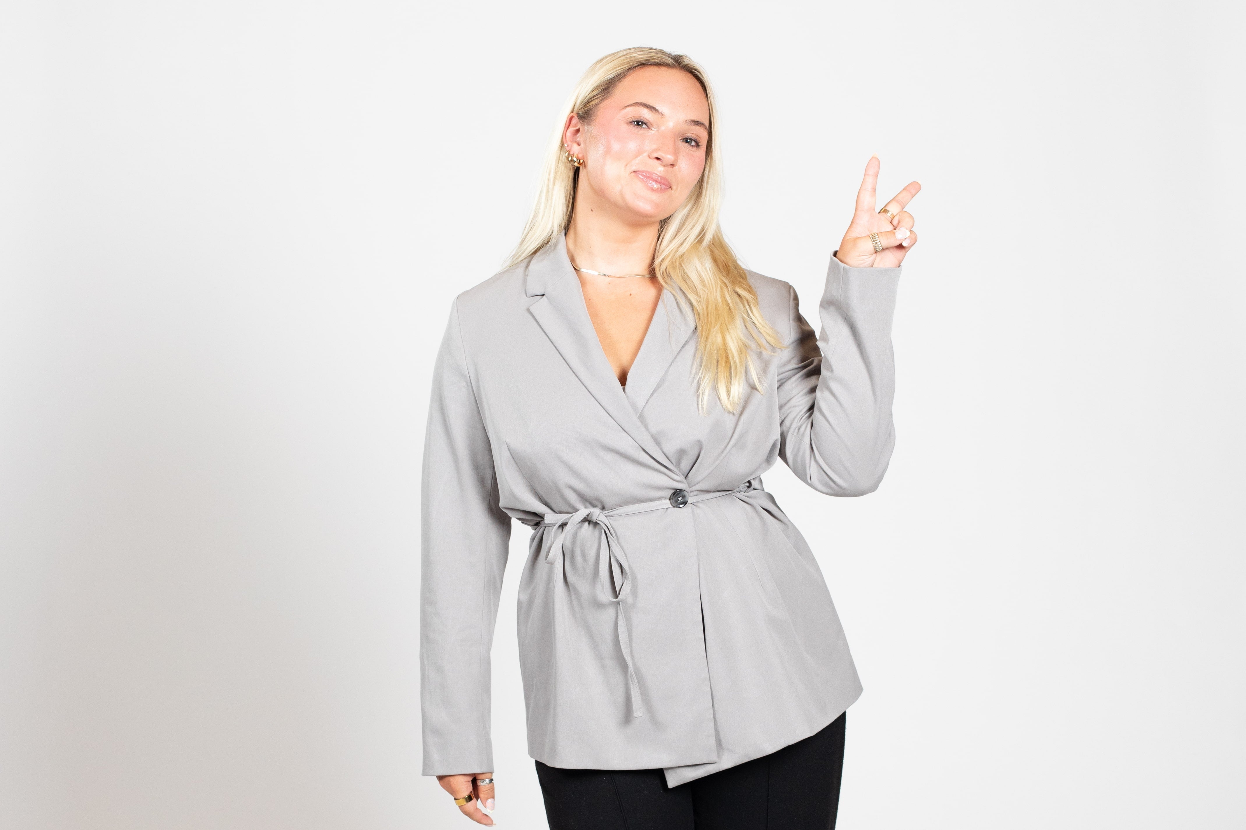 A blonde woman flashes the peace sign