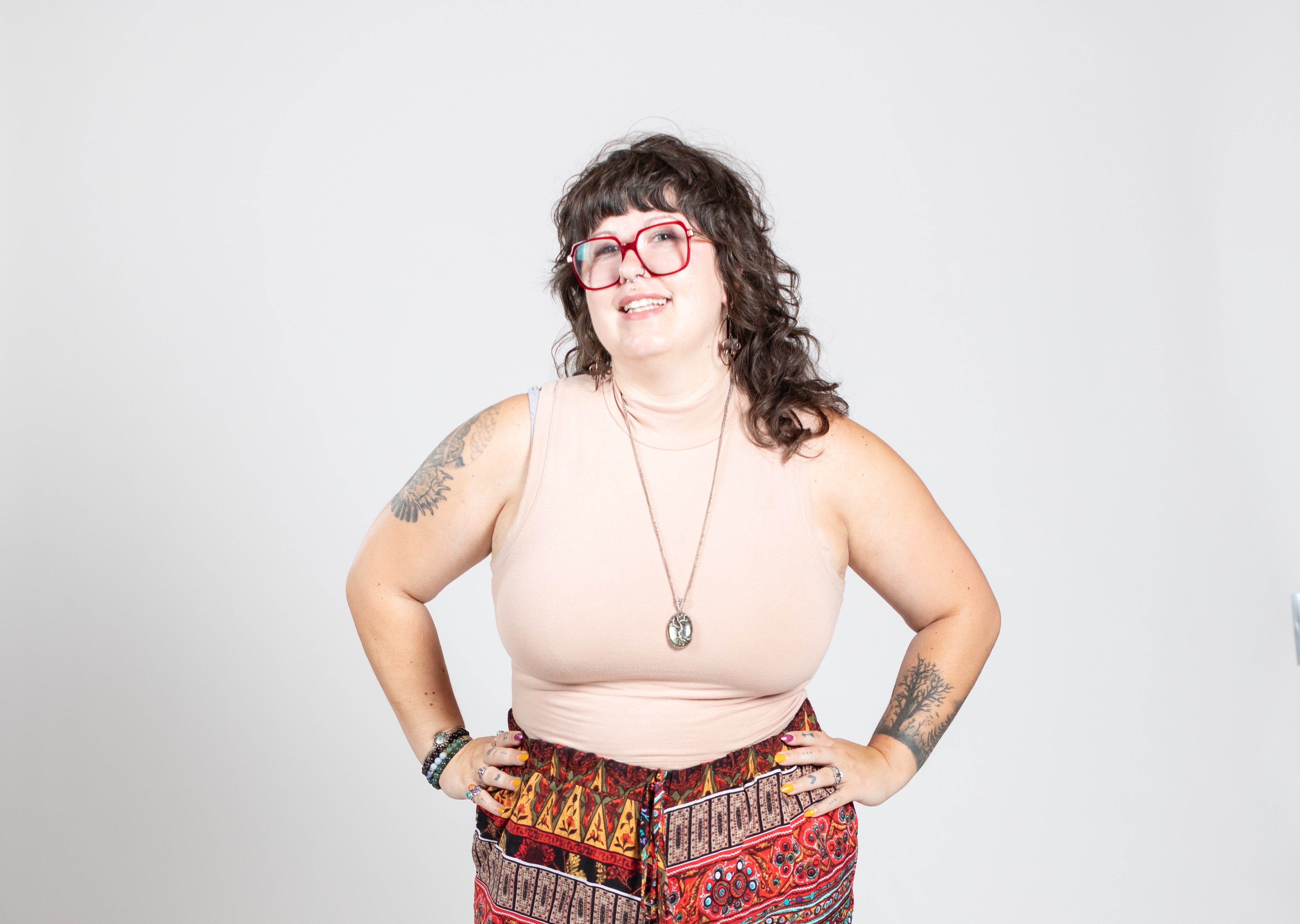 A woman with dark hair wears red glasses.