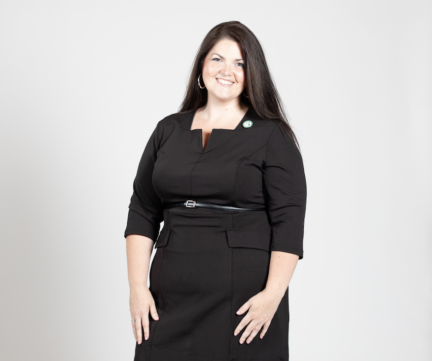 A woman with long brown hair wears a black dress.