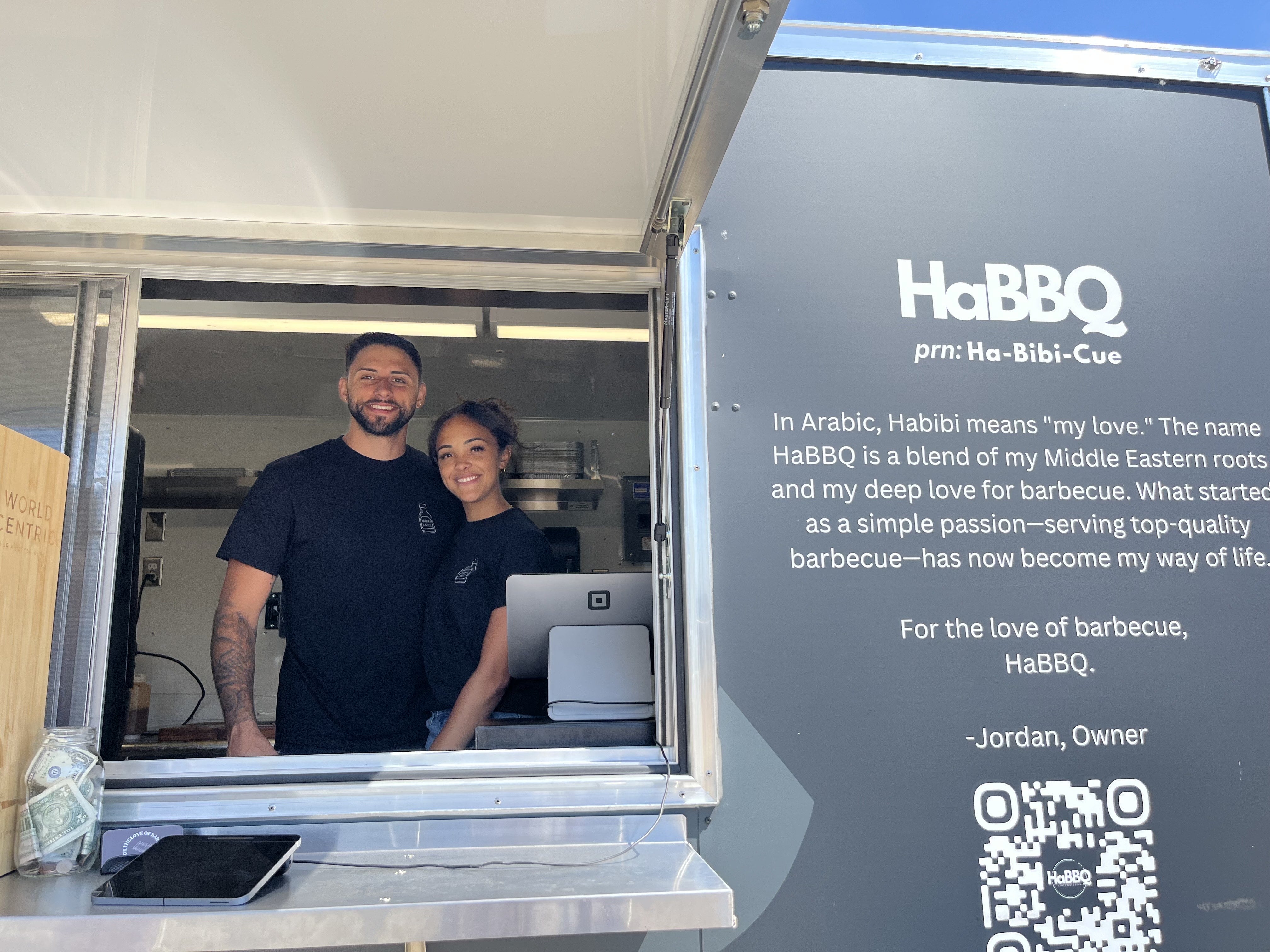 A man and a woman stand in a food truck.