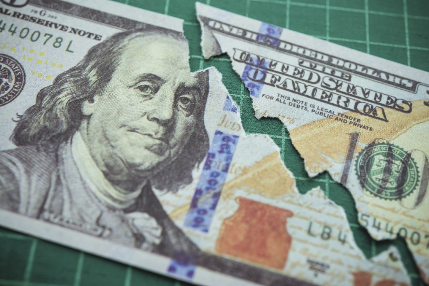 A illustration with a $100 bill showing a falling line graph.