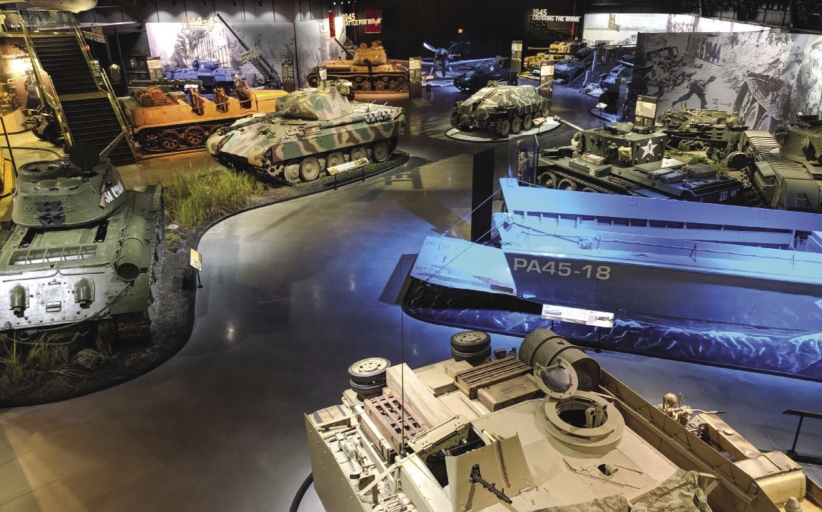 A large room featuring a number of WWII era tanks and equipment.