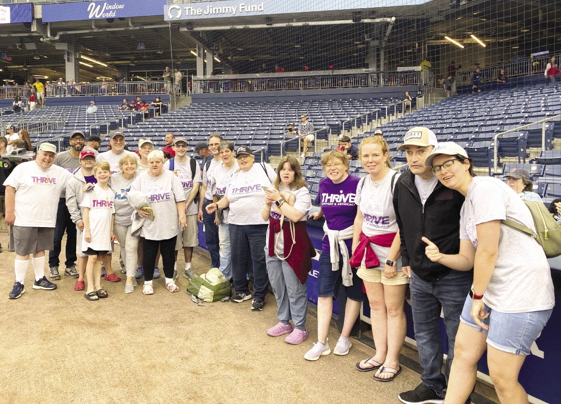 A group of people stand behind home plate on the field at Polar Park